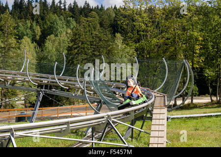 Mädchen auf Wiegand Sommer Rodelbahn Sport Folie im Skigebiet Czarna Gora (Black Mountain). Glatz, Niederschlesien, Polen Stockfoto