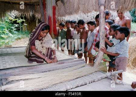 Frau, die Kindern beibringt, wie man Teppiche macht und webt, in ihrem Dorf im Bundesstaat Orissa an der Ostküste Indiens - 1992 Stockfoto