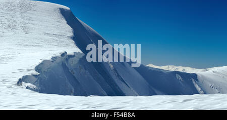 Winter Berge Grat mit Überhang Schnee Kappen auf blauen Himmelshintergrund (Ukraine, Karpaten, Svydovets Reihe, Blyznycja Berg). Stockfoto