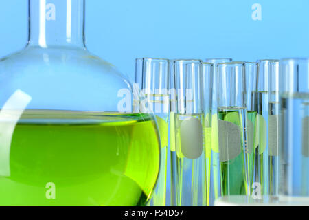 Laborglas auf blauem Hintergrund mit farbigen Flüssigkeiten gefüllt Stockfoto