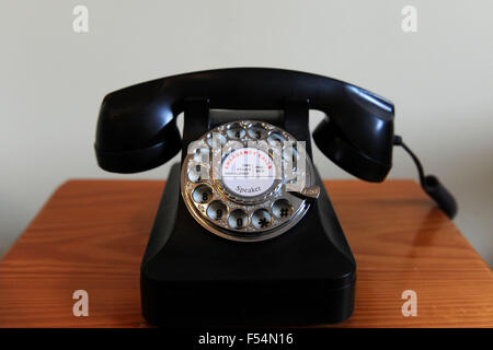 Ein Vintage altes Telefon mit Wählscheibe auf einem Holztisch. Stockfoto