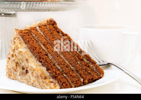 Stück deutscher Schokoladenkuchen Closeup mit Tasse Kaffee.  Isoliert auf weißem Hintergrund. Stockfoto