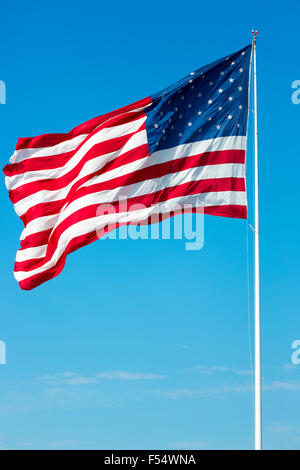 Stars And Stripes amerikanische Flagge weht im Wind vom Fahnenmast am blauen Himmel Tag in USA Stockfoto