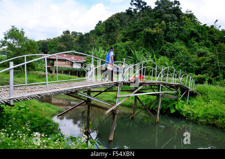 Thai-Frauen-Porträt mit Kindern Angeln auf Bambus-Brücke im Baan Natong Village am 30. August 2015 in Phrae, Thailand Stockfoto