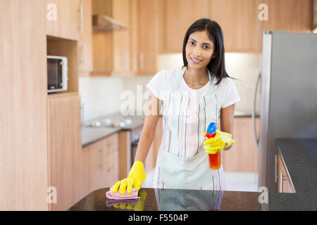 glückliche junge Inderin Reinigung Küchentheke Stockfoto