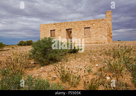 Ruinen der historischen 19. Jahrhundert Carcory Gehöft, Landhaus aus Stein umgeben von einheimischen Pflanzen unter Gewitterhimmel, outback Australien Stockfoto