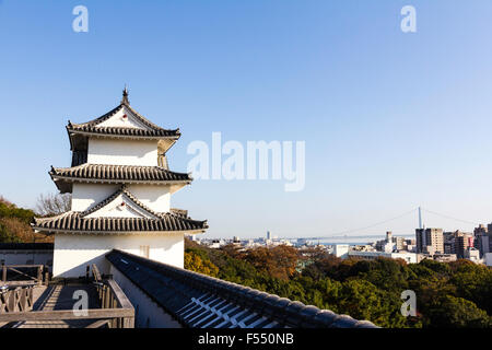 Japan, Nishi-Akashi. Hill Top Akashi schloss. Die tatsumi Yagura, einem dreistöckigen Turm. Von entlang dobei Wand gesehen. Akashi Brücke im Hintergrund. Stockfoto