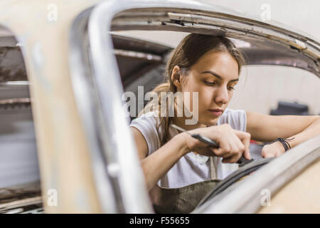 Weibliche Mechaniker Reparatur Autos in der garage Stockfoto