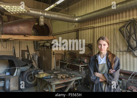 Porträt von zuversichtlich weibliche Mechaniker mit verschränkten in Werkstatt Stockfoto