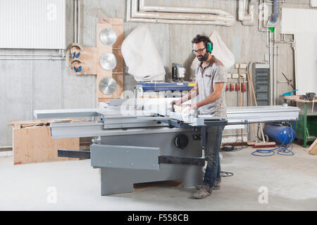 Voller Länge der Tischler mit einem Schiebetisch sah in Werkstatt Stockfoto