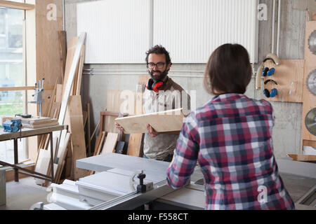 Männliche und weibliche Zimmerleute arbeiten zusammen in Werkstatt Stockfoto