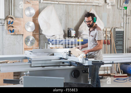 Männliche Zimmermann mit einem Schiebetisch sah in Werkstatt Stockfoto