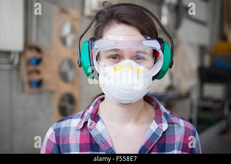 Porträt von weiblichen Zimmermann in Schutzkleidung beim workshop Stockfoto