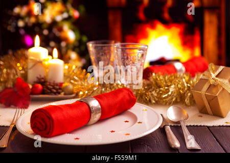 Weihnachten Tisch romantisch mit Kerzen und Weihnachtsschmuck. Brennt ein Feuer im Kamin und Christm Stockfoto