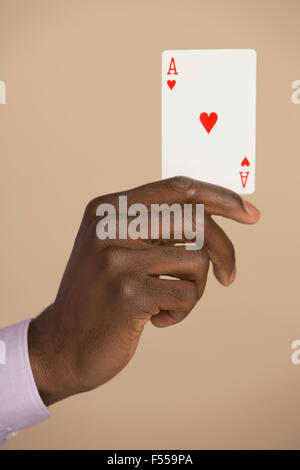Hand, die Ass-Karte vor farbigen Hintergrund abgeschnitten Stockfoto