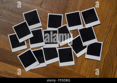 Leere Sofortbildkamera druckt auf Holztisch Stockfoto