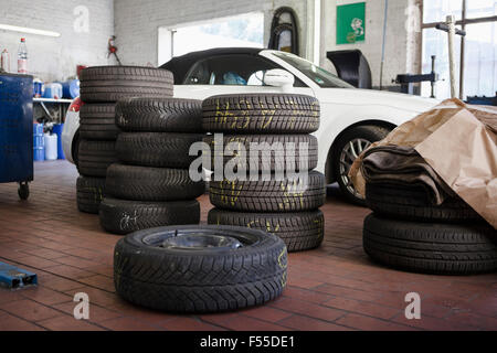 Gestapelten Reifen mit dem Auto in der garage Stockfoto