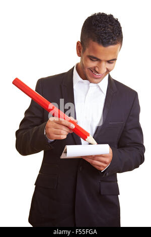 Junger Geschäftsmann mit einem überdimensionalen roten Bleistift Stockfoto