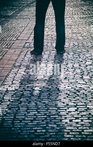 Geheimnisvollen männlichen Figur stehend in einer gepflasterten Straße Stockfoto