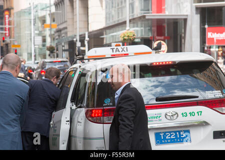 australische Taxis in George Street Sydney mit Geschäftsleuten aus der Kabine, Sydney, Australien Stockfoto