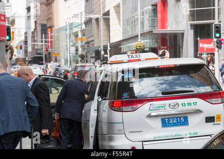 australische Taxis in George Street Sydney mit Geschäftsleuten, die Abfahrt bezahlt ihre Kost, Sydney, Australien Stockfoto