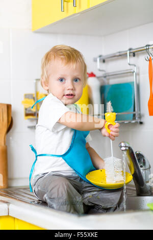 Kind junge Abwasch und Spaß in der Küche Stockfoto