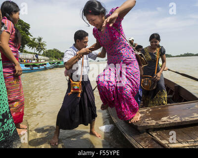 Kyauktan, Division in Yangon, Myanmar. 28. Oktober 2015. Eine Mädchen springt eine Fähre nach der Rückkehr aus Kyaik Hmaw Wun Pagode, eine Pagode auf einer Insel ca. zwei Stunden von Yangon während des Thadingyut Festivals. Das Thadingyut Festival, die Beleuchtung Festival von Myanmar, ist am Vollmondtag des birmanischen lunaren Monats des Thadingyut statt. Als ein Brauch ist es am Ende der buddhistischen Fastenzeit (Vassa) statt. Das Thadingyut Festival ist die Feier, die Buddha Abstieg vom Himmel begrüßen zu dürfen. © Jack Kurtz/ZUMA Draht/Alamy Live-Nachrichten Stockfoto