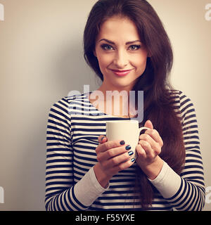 Niedliche Junge lässige Frau hält in der hand Tasse Tee. Vintage getönten Porträt. Closeup Stockfoto