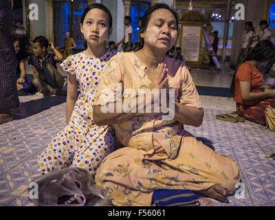 Yangon, Yangon Division, Myanmar. 28. Oktober 2015. Eine Frau und ihre Tochter betet während Gedenktage des Thadingyut am Botataung-Pagode in Yangon. Botataung Pagode wurde zuerst durch die Mon, eine burmesische ethnische Minderheit, etwa zur gleichen Zeit gebaut, als Shwedagon-Pagode, vor über 2500 Jahren wurde. Das Thadingyut Festival, die Beleuchtung Festival von Myanmar, ist am Vollmondtag des birmanischen lunaren Monats des Thadingyut statt. Als ein Brauch ist es am Ende der buddhistischen Fastenzeit (Vassa) statt. Das Thadingyut Festival ist die Feier, die Buddha Abstieg vom Himmel begrüßen zu dürfen. (Kredit-Bild: © Jack Kurtz über Stockfoto