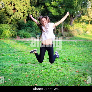 Schöne glückliche junge Teen Mädchen springen hoch im park Stockfoto