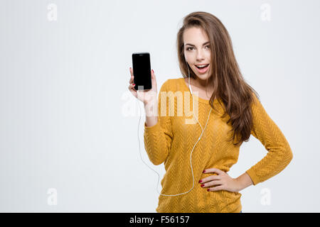 Porträt einer fröhlichen Frau zeigt leere Smartphone-Bildschirm auf einem weißen Hintergrund isoliert Stockfoto