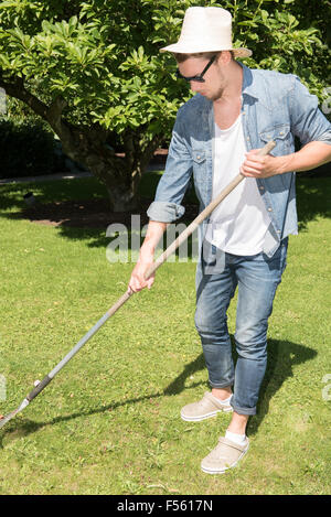 junger Mann arbeitet im Garten Stockfoto