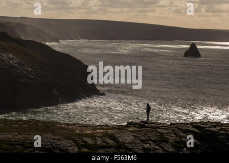 Cornish Nordküste von Tintagel Castle mit einer Person auf einem Felsvorsprung stehend. Cliffscape, Seestück Stockfoto