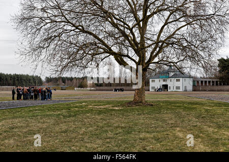 14.04.2015, Oranienburg, Brandenburg, Deutschland - Denkmal auf dem Gelände des ehemaligen NS-Konzentrationslager Sachsenhausen in Oranienburg in der Nähe von Berlin-Bezirk mit dem gleichen Namen. Das Bild zeigt eine Gruppe von Besuchern mit einem einsamen Baum vor einem angegebenen nur in ihrem Grundriss der Lagerbaracken. Im Hintergrund das Haupttor. EJH150414D249CAROEX. JPG - nicht für den Verkauf in G E R M A N Y, A U S T R I A S W I T Z E R L A N D [MODEL-RELEASE: Nein, PROPERTY-RELEASE: kein (C) Caro Fotoagentur / Heinrich, http://www.caro-images.pl, info@carofoto.pl - bei der Verwendung des Bildes für nicht-journalistischen Stockfoto