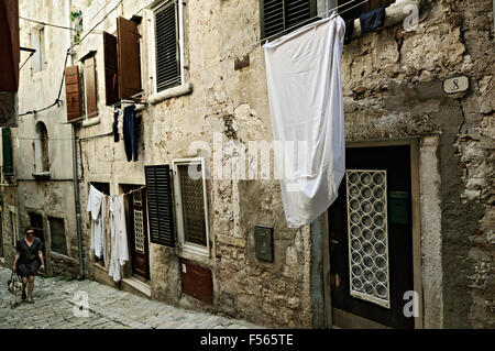 Junge Frau und Wäsche in einer alten Gasse von Rovinj, Istrien, Kroatien Stockfoto