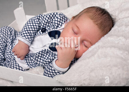 schöne Baby in das neue Jahr Kappe und weißen Körper sitzt Stockfoto