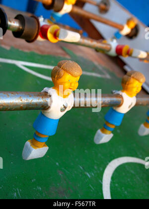 Nahaufnahme auf einem Kunststoff-Foosball Player auf einen Steuerknüppel auf einem rostigen alten Spieltisch. Stockfoto