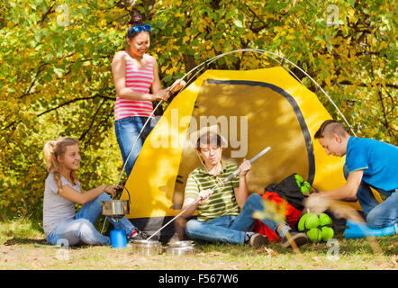 Jugendliche bauen gelbe Zelt sich im Wald Stockfoto