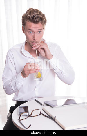 junger Geschäftsmann mit einem Glas Wasser Stockfoto