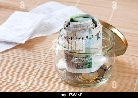 Geld sparen und Quittungen, polnische Zloty furled Banknoten Haufen und Münzen sammeln aus transparentem Glas jar stehen... Stockfoto