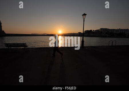 Eine junge Frau Spaziergänge entlang des Ufers des venezianischen Hafen bei Sonnenaufgang in Chania auf Kreta in Griechenland Stockfoto