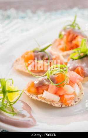 Lachs-Ceviche serviert auf Taro Chips garniert mit Poi und Frühlingszwiebeln garnieren Stockfoto