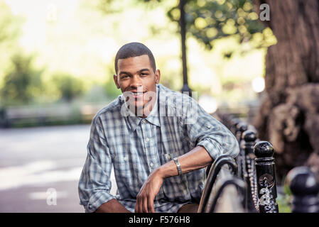 Ein Mann sitzt in einem Stadt Park auf einer Bank Stockfoto