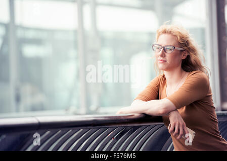 Eine Frau im freien umzusehen, ein Handy in der Hand. Stockfoto