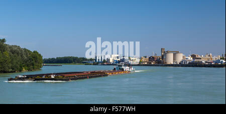 Eine funktionierende Kahn Reisen entlang der Donau vor den Toren Wien. AGRANA-Essen-Raffinerie im Hintergrund. Stockfoto