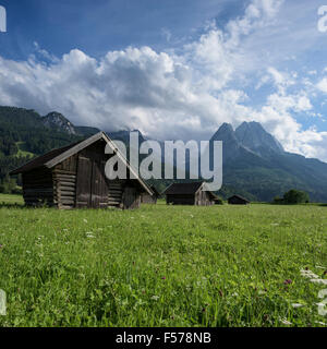 Hölzerne Heustadel im Feld mit den Bergen im Hintergrund, Garmisch-Partenkirchen, Bayern, Deutschland Stockfoto