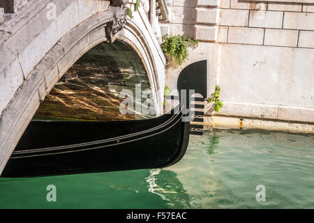 Gondel unter einer Brücke in Venedig, Italien. Venezianische Impressionen prägt Fluidität Struktur Wasser. Stockfoto