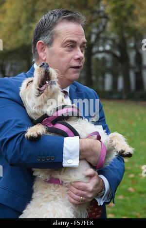 London, UK. 29. Oktober 2015. Nigel Adams MP, Selby und Ainsty, mit seinem Labrador/Pudel cross Evoli. Mitglieder des Parlaments und ihre Hunde Pfoten für einen Sieg in der jährlichen Westminster Dog of the Year Wettbewerb organisiert von Dogs Trust und der Kennel Club. Bildnachweis: Lebendige Bilder/Alamy Live-Nachrichten Stockfoto