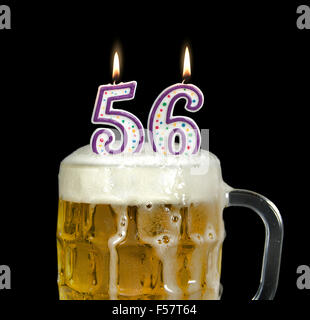 Geburtstagskerzen in Krug Bier zum 56. Geburtstag auf schwarz. Stockfoto