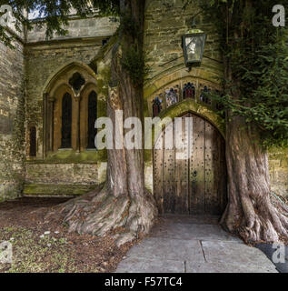 Die Nordtür der St. Edwards Kirche mit zwei alten Eibe Bäume beiderseits Stow auf die würde, Gloucestershire, England, UK Stockfoto